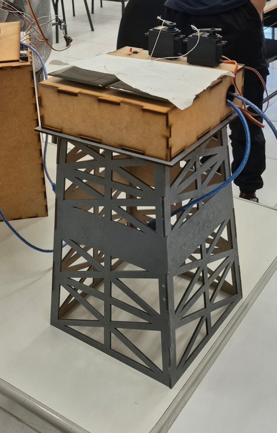Protótipo físico de uma plataforma offshore em MDF, com um painel solar, servomotores e fiação sobre a estrutura